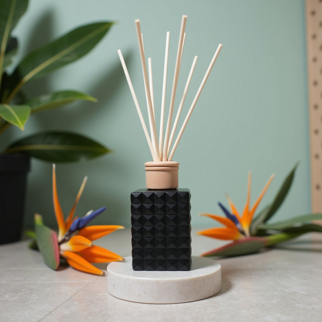 A luxurious Birds of Paradise floral reed diffuser in a matte black bottle.