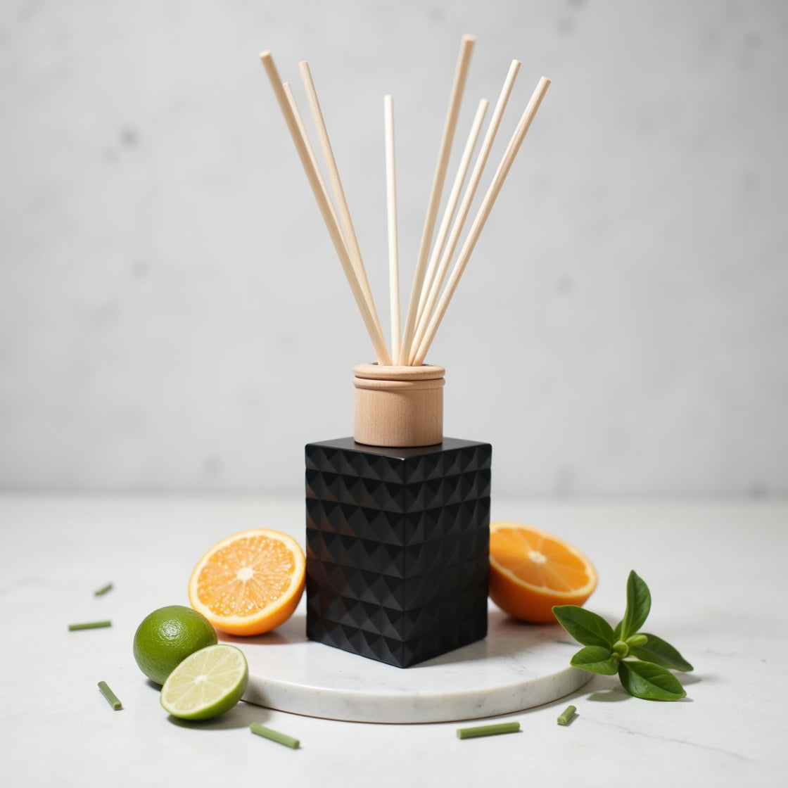 A Lime, Basil & Mandarin reed diffuser in a sleek matte black bottle.