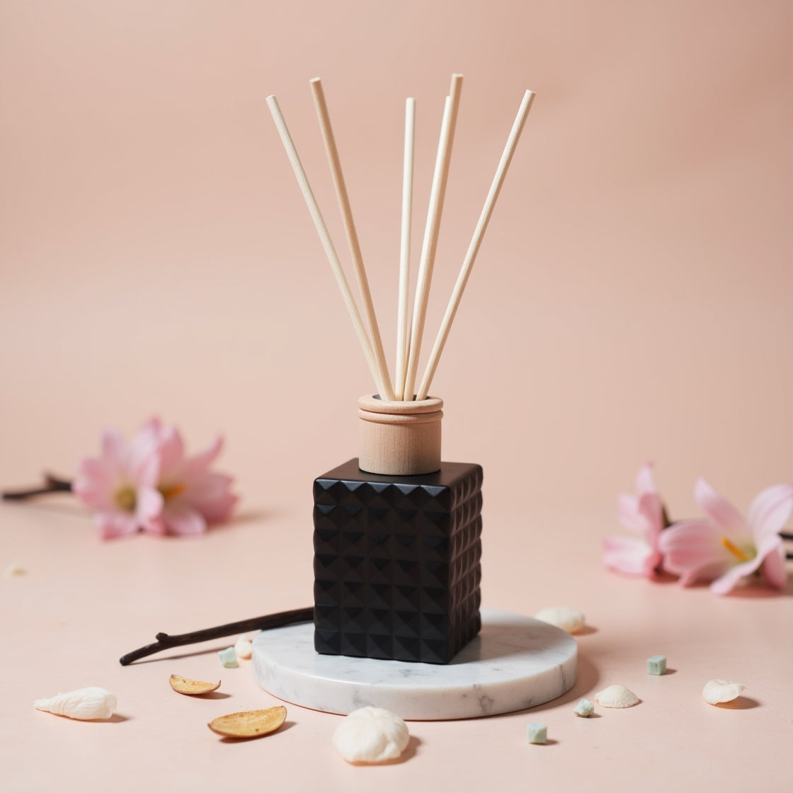 A soft floral Sweet Pea & Vanilla scented reed diffuser in a matte black bottle.